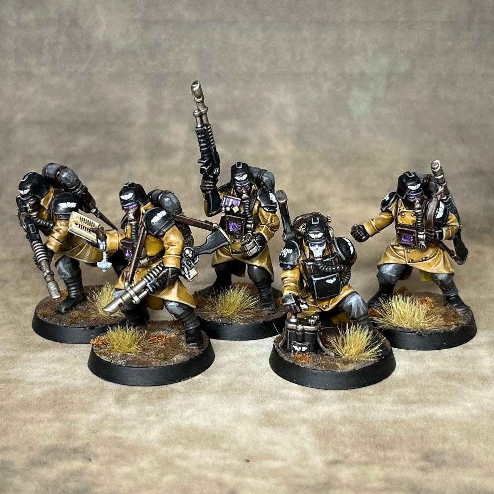 Five death korps of Krieg infantry in yellow and black steel legion colours including an engineer, a veteran and a guardsman reading a primer