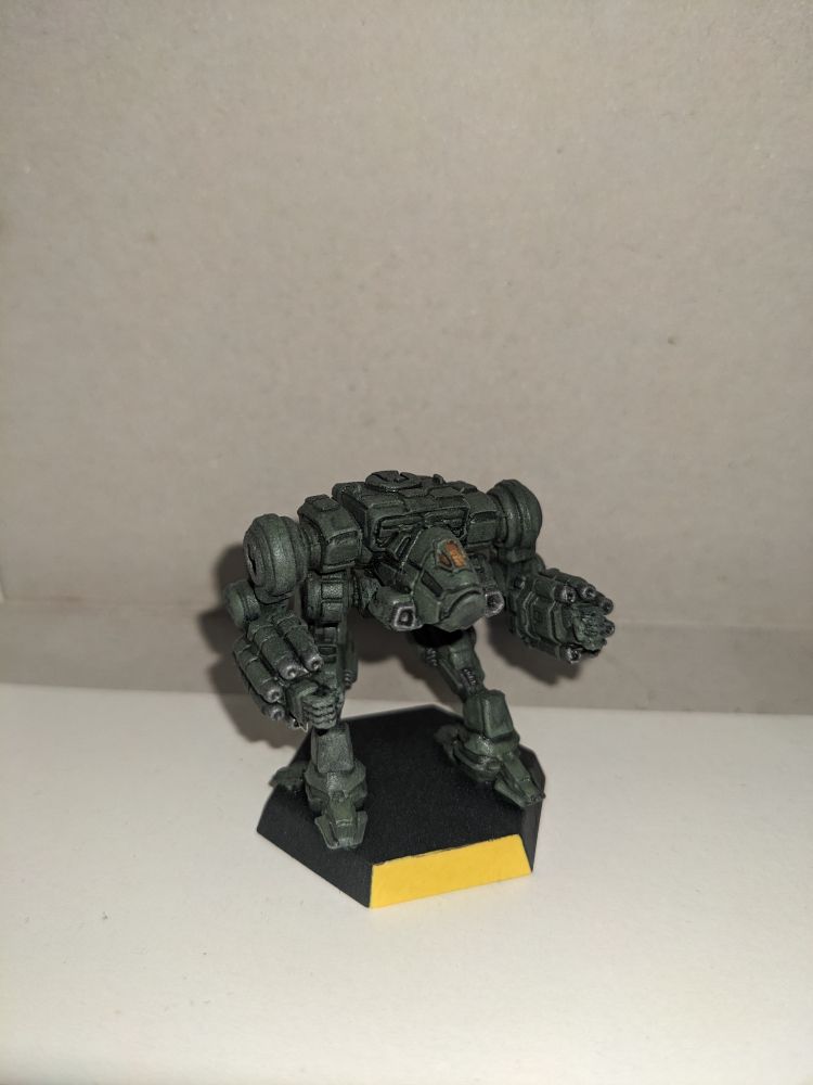 A single plastic Nova miniature painted military green facing front.