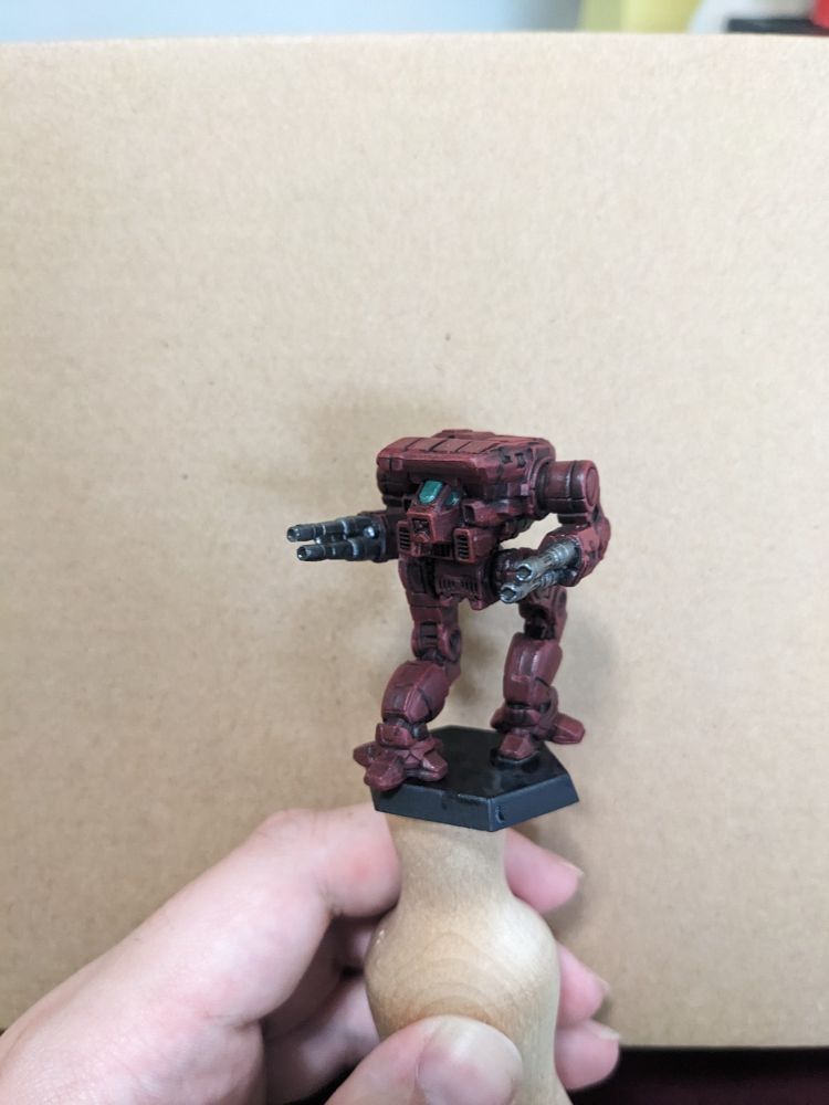 A Warhawk miniature painted dark red with metallic green details on the cockpit.