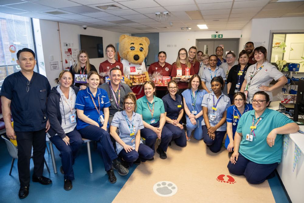 Members of staff from the Lister Hospital children's departments are photographed alongside footballers from Stevenage Football Club, as well as Boro Bear, during an Easter visit.