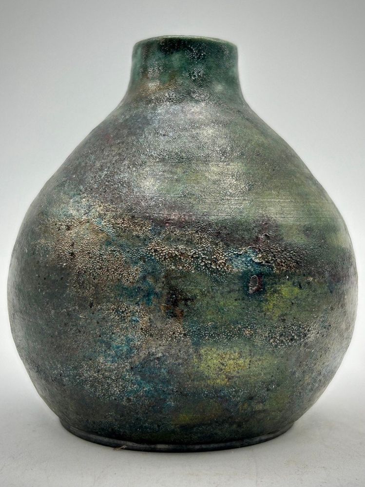 A raku pottery vase called 'Forest Nebula' in shades of greens, metallics with some reds and coppers.