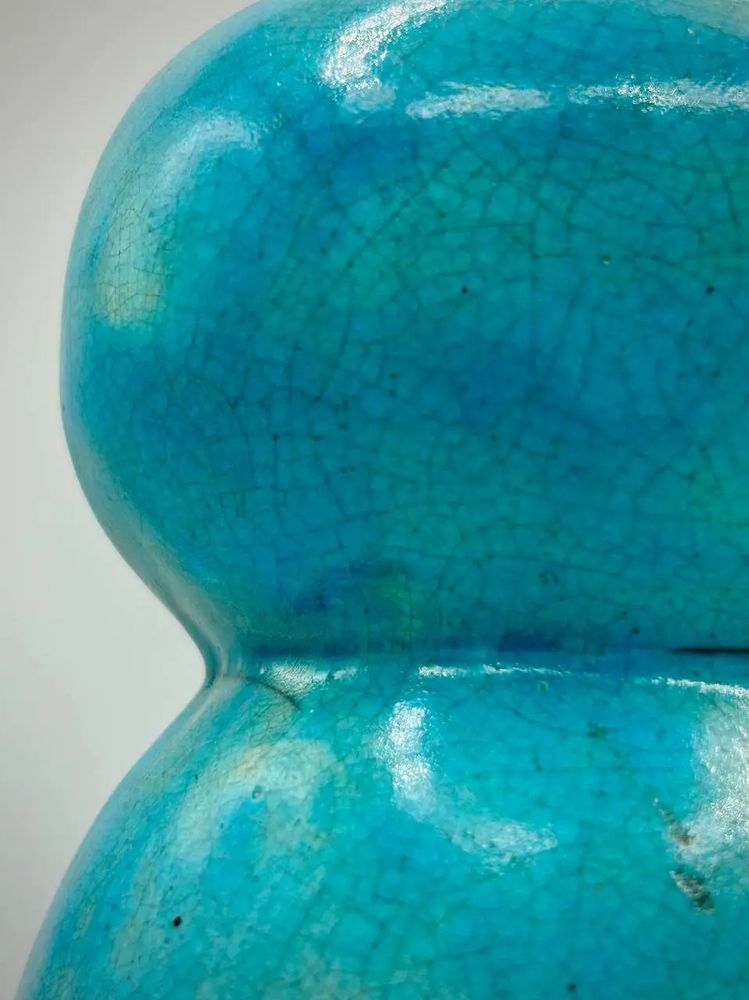 A closeup of the raku crazing on the back of the head of a turquoise ceramic owl 
