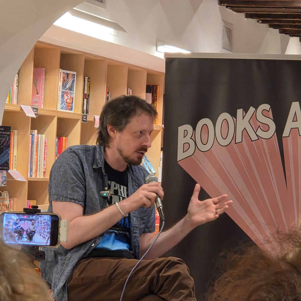 Nat with a mic and gesturing excitedly 