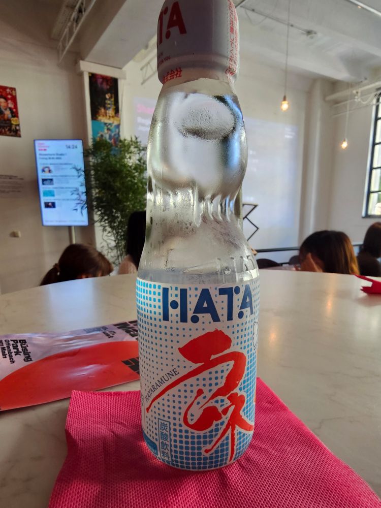 Gasflasche mit Limo und einer Glaskugel, die man erstmal mit einem Stöpsel reinhauen muss, damit sie sich öffnet. Durch die Kohlensäure gibt's erstmal einen Sprudel. 