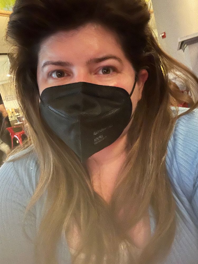 Brunette in a blue sweater and a black mask
