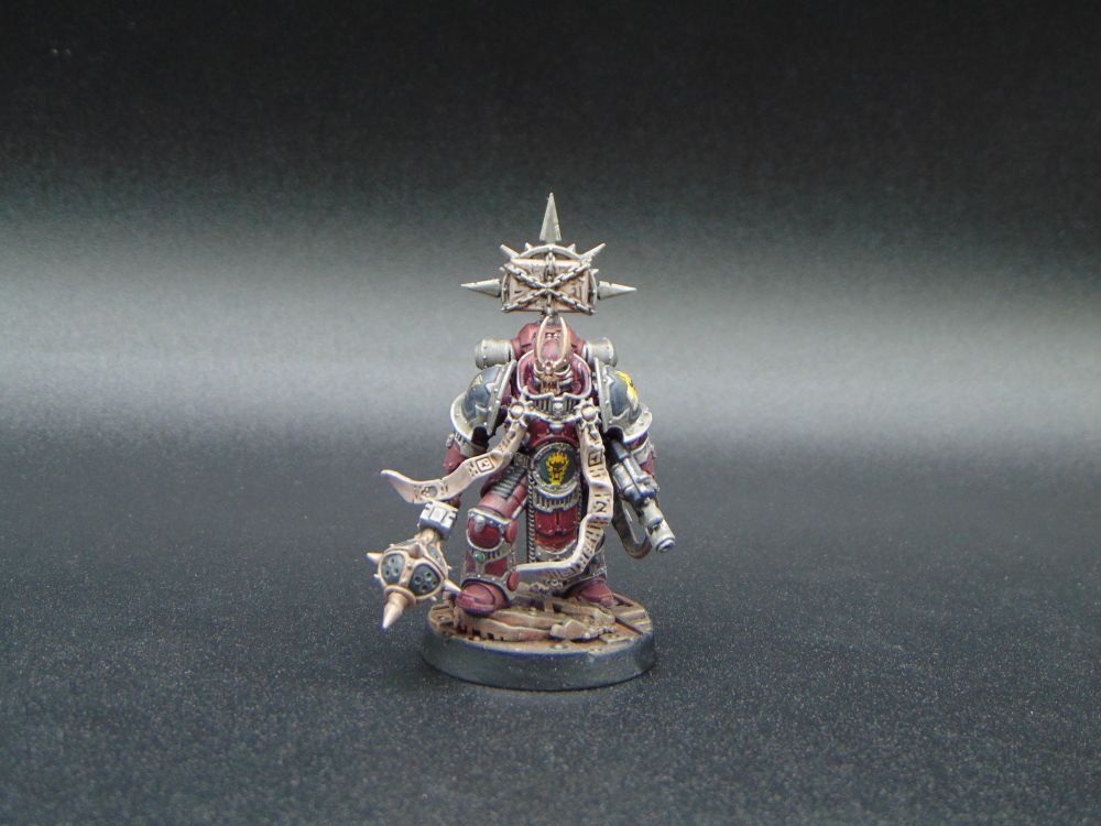 A painted Mark 2 Centurion figure for Warhammer the Horus Heresy. It is painted in red and black to represent Word Bearers' colours. The figure is based on the Saturnine Centurion figure, its head is taken from the Word Bearers upgrades set, its weapon is from the old Deathwing Knights. The figure has chest parchment straps taken from the Warhammer 40,000 Dark Apostle figure, and a book on the backpack from the Kill Team Legionaries upgrade sprue