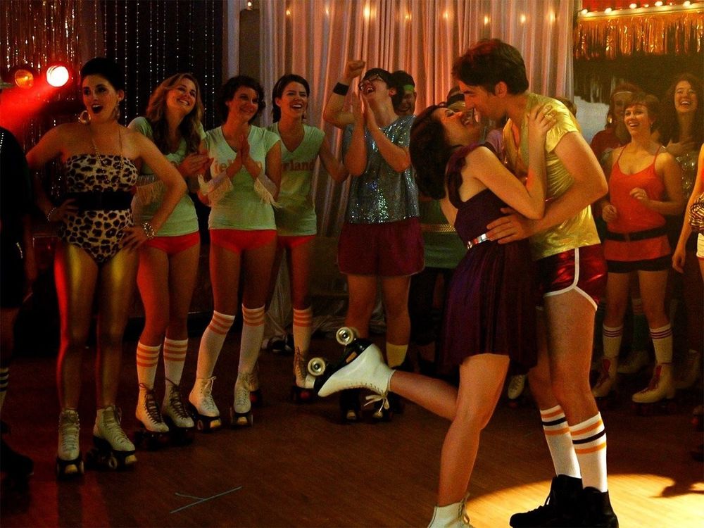 A still from the movie ROLLER TOWN depicting a lot of people wearing roller skates and dressed in high early 80s fashion.