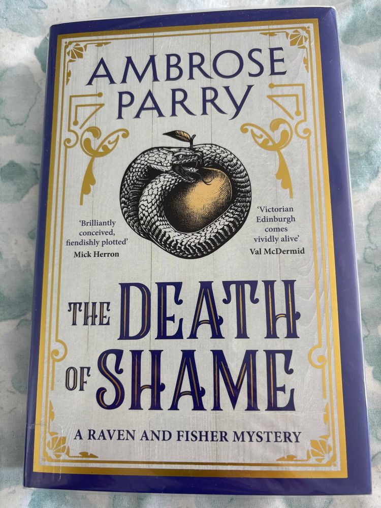 Front cover of Ambrose Parry novel Tbe Death of Shame in pristine plastic library book jacket 
