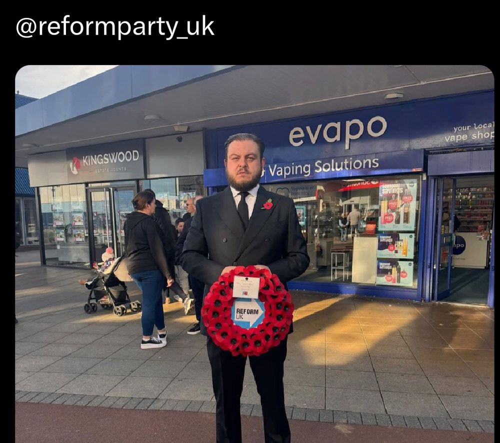 Reform councillor with poppy wreath outside a vape shop called 'evapo'