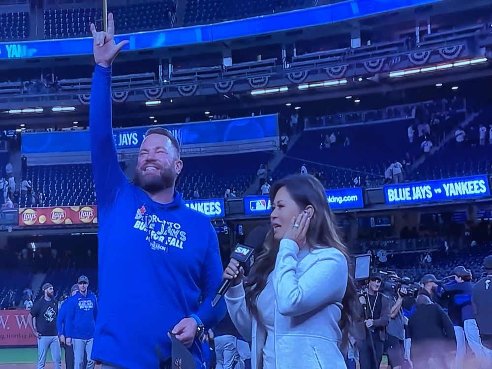 Blue Jays manager John Schneider celebrates as he’s about to be interviewed by Hazel Mae
