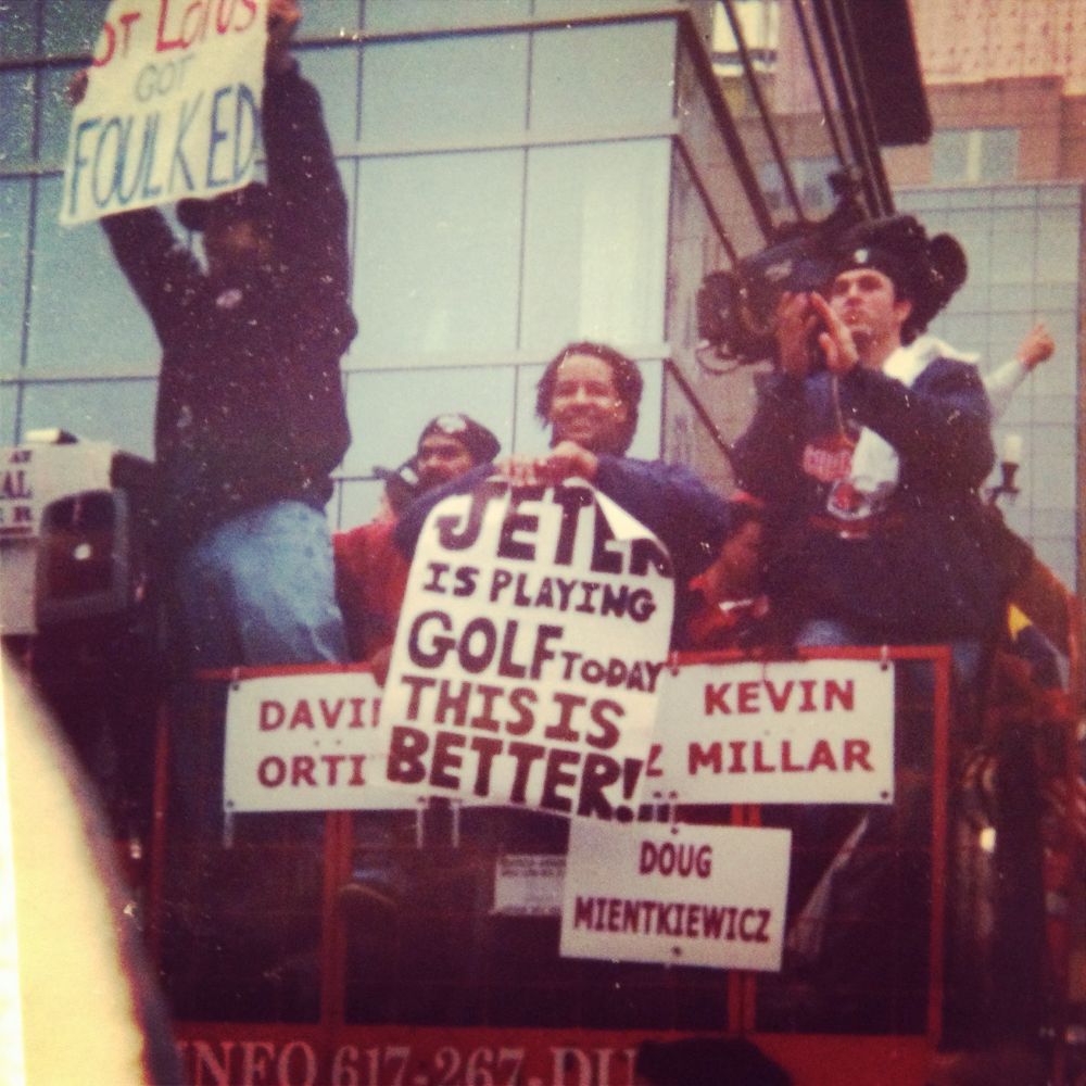 A photo taken by me at the 2004 Red Sox championship parade. Four players (David Ortiz, Manny Ramirez, Kevin Millar, and Doug Mientkiewicz) are riding on a red duck boat. Manny Ramirez holds a sign from stating “Jeter is playing golf today, this is better!” and Kevin Millar is standing on a rail holding a sign stating “St. Louis Got Foulked!” It is awesome. 