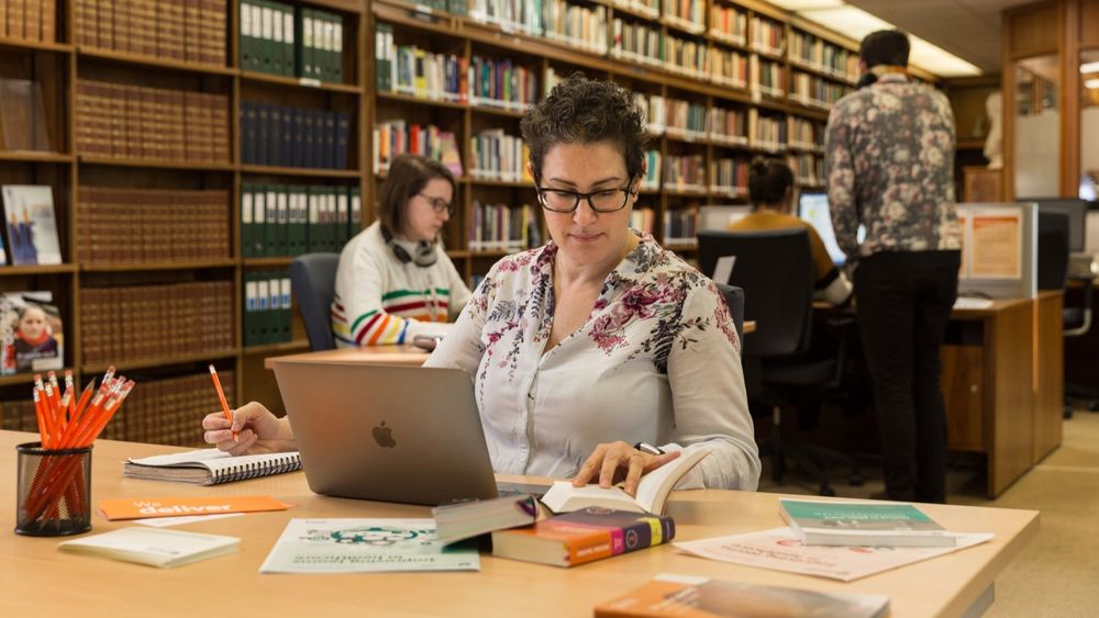 Professional sat with a laptop in library