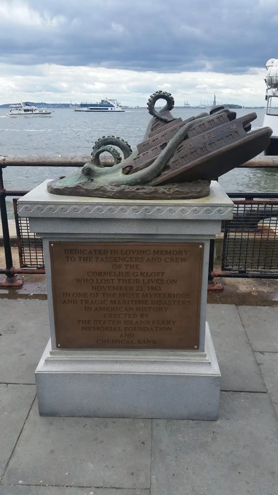 A plaque with a statue showing a giant octopus pulling a ferry beneath the waves.  A faded bronze inscription memorializes the sunken ferry.  