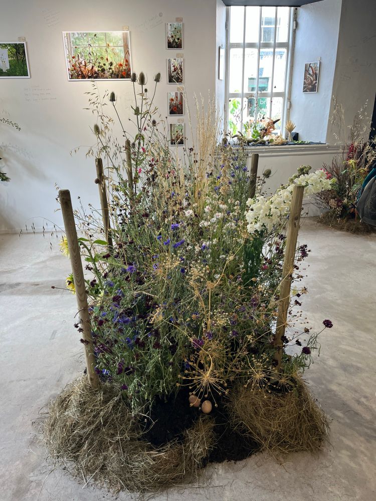 A large arrangement of flowers on a gallery floor