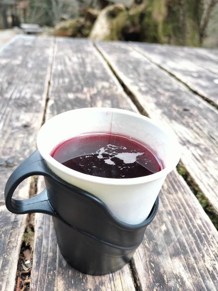 御岳山、長尾茶屋にて。雪空の下、木のテーブルに置かれたホットワイン。