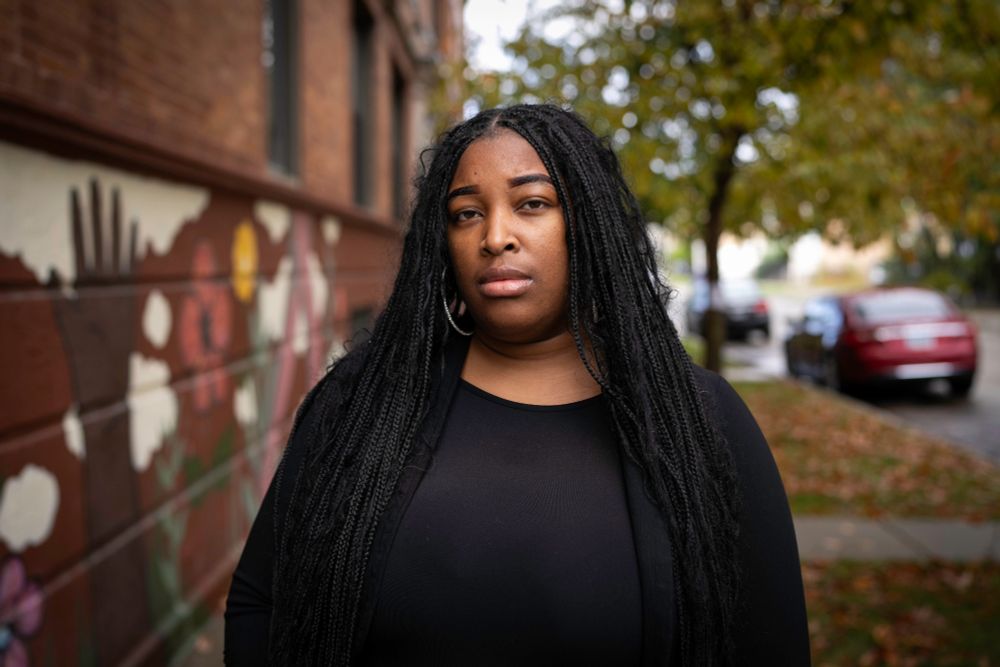 A portrait of a woman standing in a street.