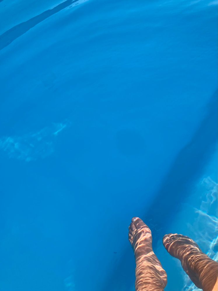 Deux pieds se délassent dans la piscine 