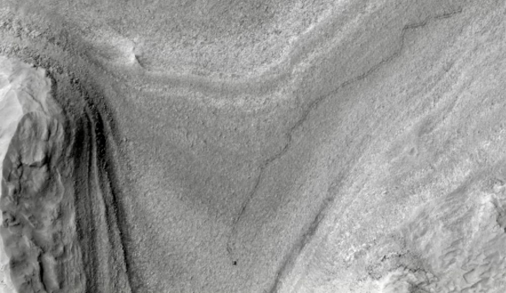 Alt text from the NASA Jet Propulsion Laboratory website: NASA’s Curiosity rover appears as a dark speck in this contrast-enhanced view captured on Feb. 28, 2025, by the HiRISE camera aboard NASA’s Mars Reconnaissance Orbiter. Trailing Curiosity are the rover’s tracks, which can linger on the Martian surface for months before being erased by the wind.