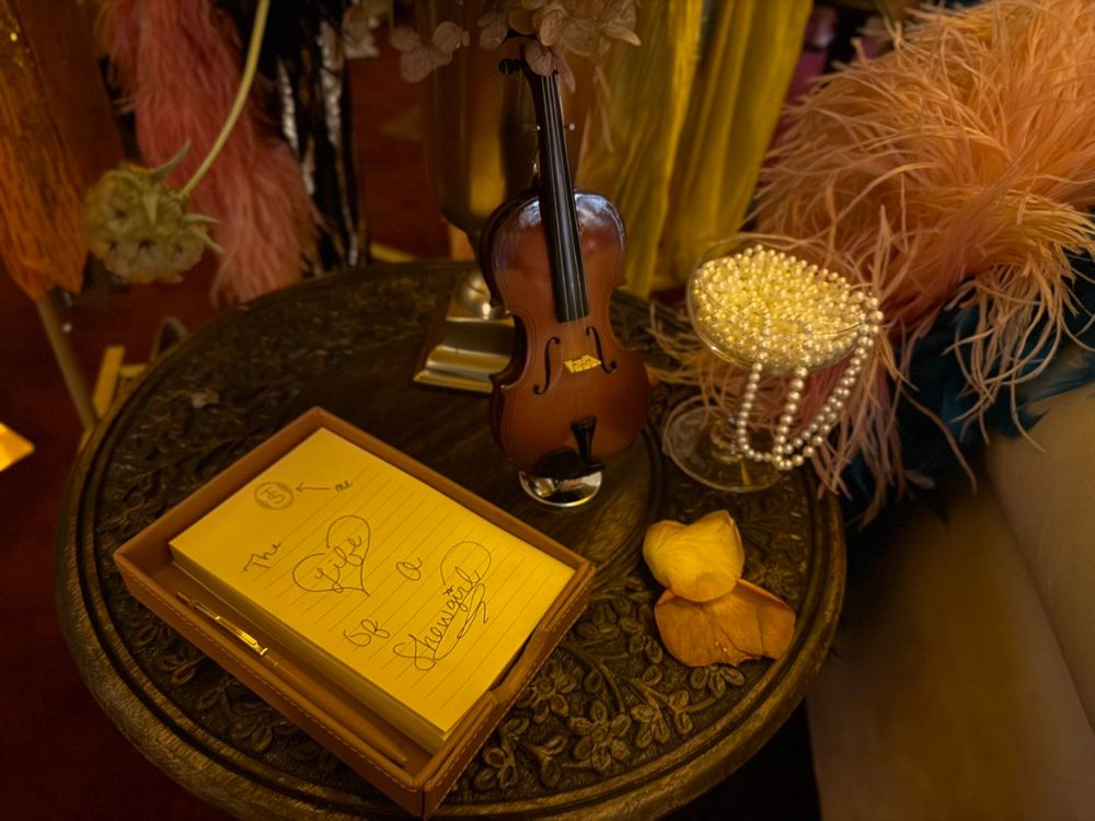 A yellow notepad with handwritten words “The life of a Showgirl” and some doodles. The word life is inside a heart.