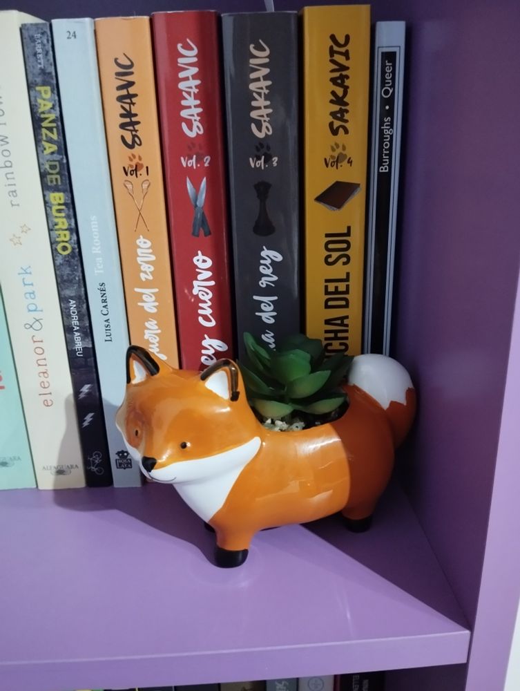 Foto de una balda de mis estanterías. Sale una figurita de un zorrito con una plantita falsa encima. Está al lado de los libros de all for the game