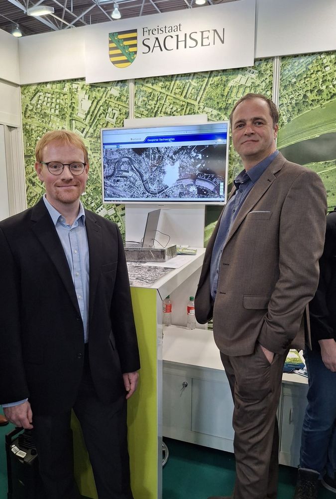 Matthias Forkel and Christopher Marrs presenting historical spy imagery at the booth of the Saxon state office for Geoinformation at the book convention in Leipzig