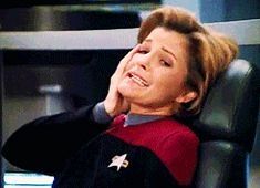Janeway from Star Trek Voyager, one hand on her cheek, grimacing with confused horror