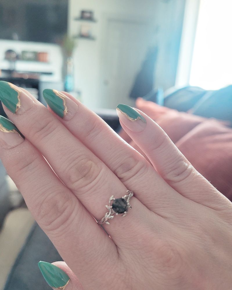 Long manicure with green and gold splashed across half the nails.
