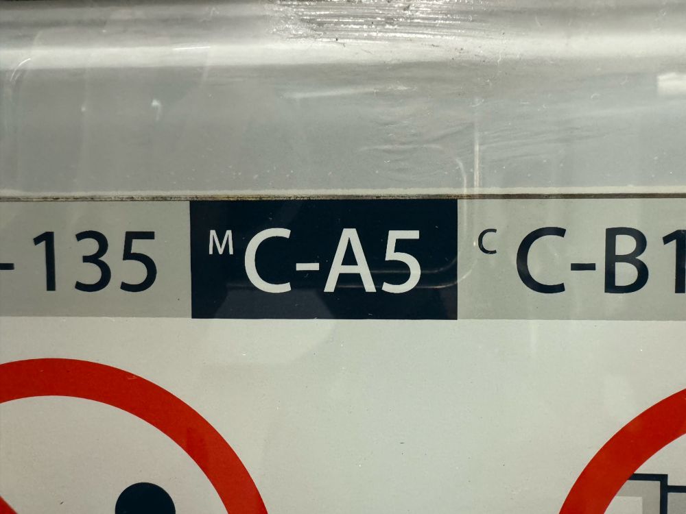 A closeup picture of a decal specifying train specs at a Hong Kong MTR subway train platform. The center square, white text on a deep blue background, says C-A5. The Myriad Pro typeface used by the Hong Kong subway is that of the Apple corporate typeface in 2011, the year where the Apple’s dual-core A5 chip was launched. 

The joke is that the train has the Apple A5 hardware because of the typeface and A5 insignia. 