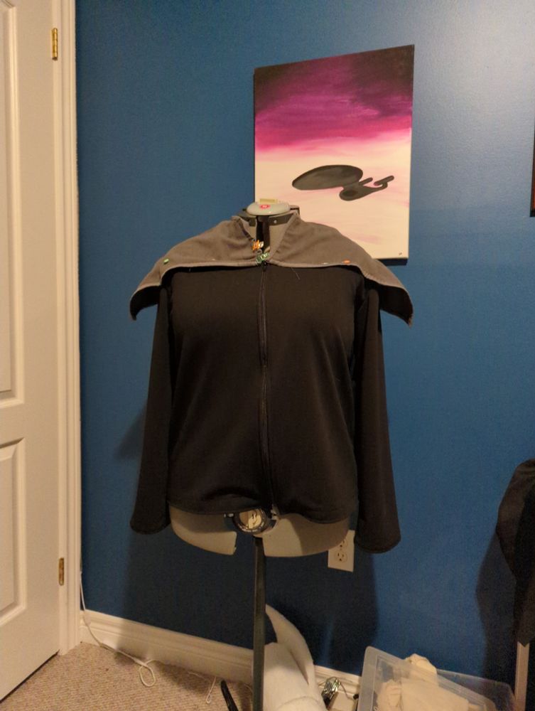 A work in progress DS9/First Contact era Star Trek costume draped over a mannequin. The grey points on the shoulders are splayed out and are awaiting being sewn down 