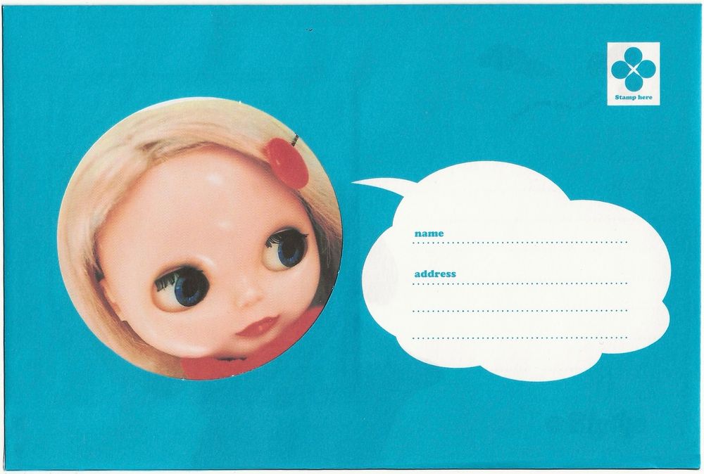 Blythe letter set featuring a Blythe doll with blonde hair. The blue envelope has a window that fits perfectly over her face. There is a text bubble that has space for writing the recipient's name and address. 