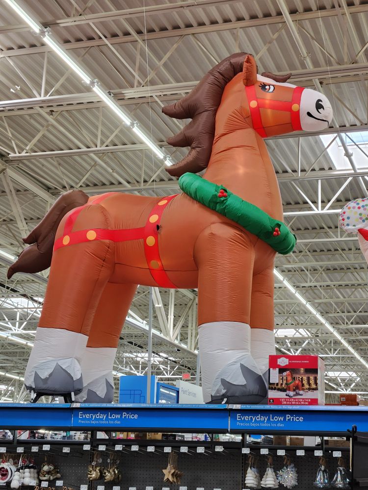 A very large Airblown inflatable holiday Clydesdale horse on display inside a Walmart store