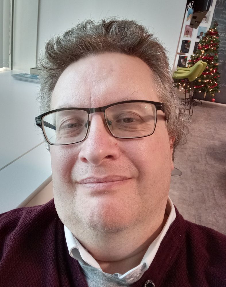 A fairly bland middle aged man in glasses.