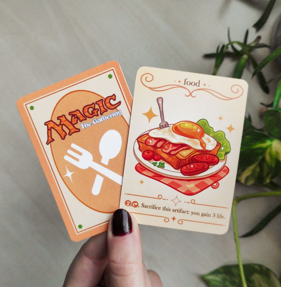 Photo of the front and back of a Magic the Gathering token card personalised by me with an illustration of a breakfast toast