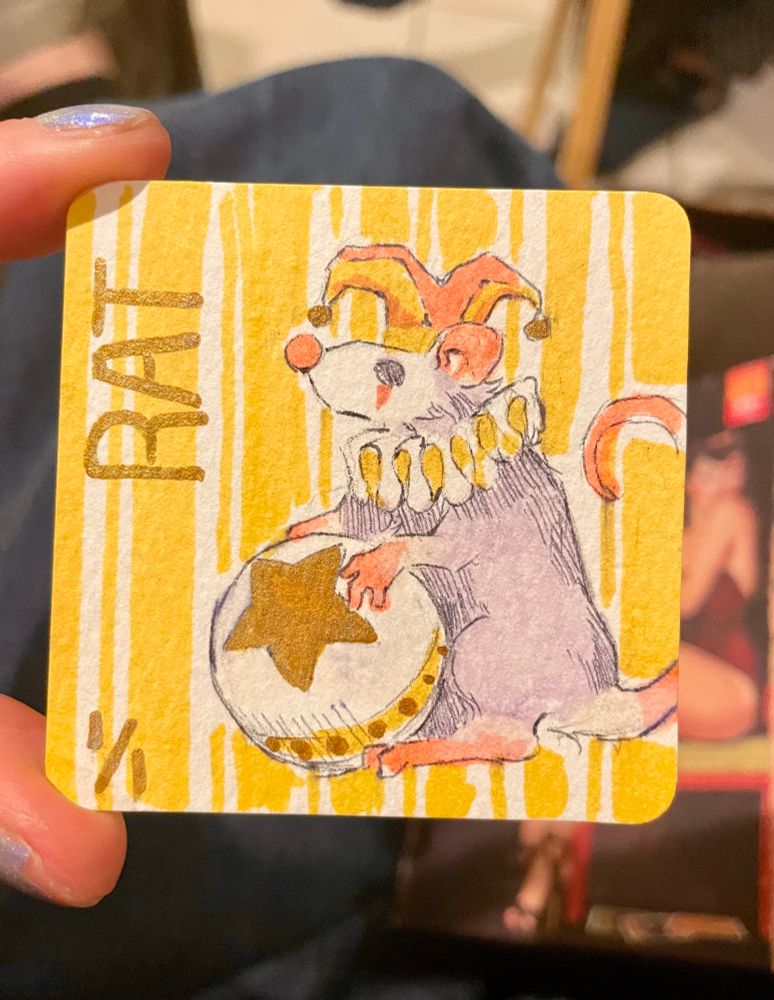 This is a sad clown circus rat. He’s got a silly jester cap and a large ball with a gold star on it.