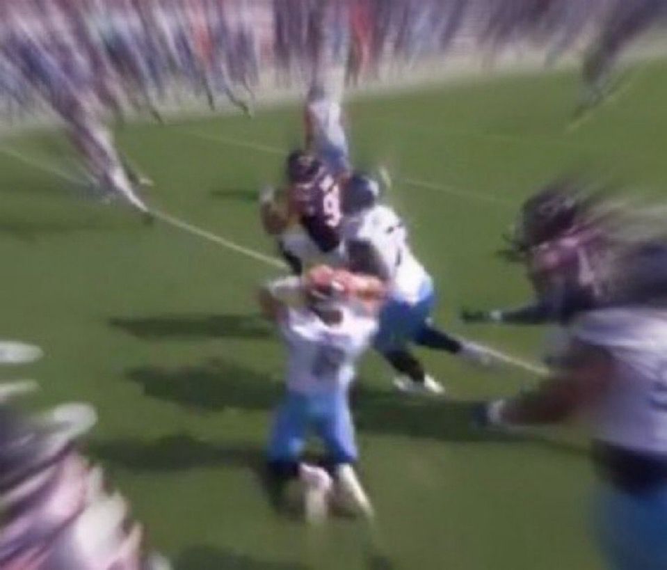 Heavily blurred image of Will Levis mid-game, on his knees with his hands behind his helmet in dismay, having just thrown an INT that’s being returned for a TD before his eyes.