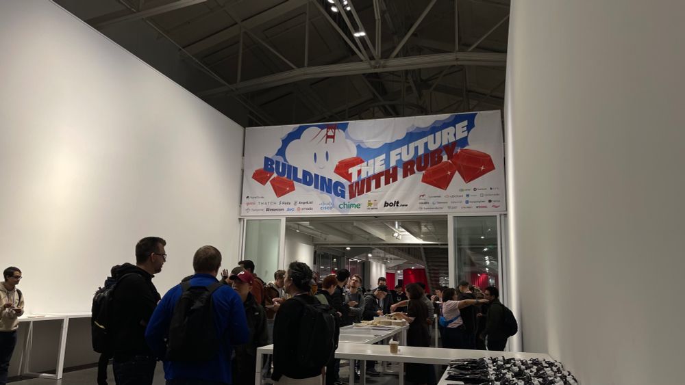 Rubyists in the entrance hallway, with a big "Building the Future with Ruby" banner above the people