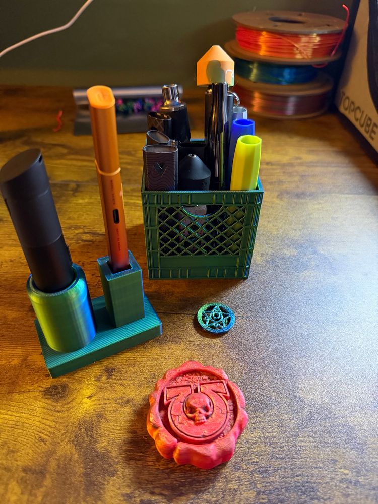 3d printed objects. A warhammer purity seal, a stand for a puffco proxy and hit knife and a small milk crate for batteries, also a small sailor moon themed fan cover 