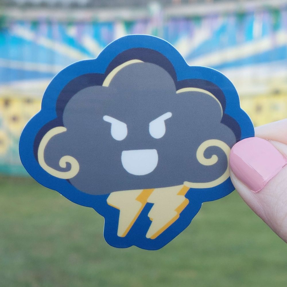 A storm cloud sticker that's gray with yellow lightning bolts below it. It's face is doodled with white lines and it looks mischievous with slanted brows.