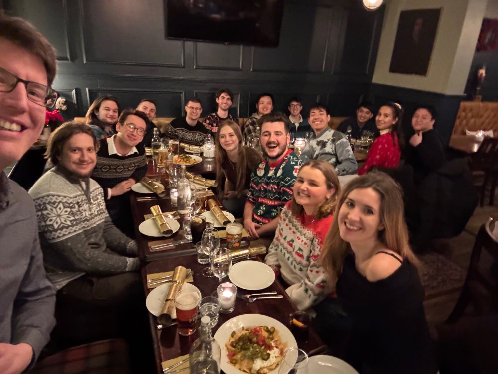 Bull Group at table ahead of a meal on a lab Christmas party