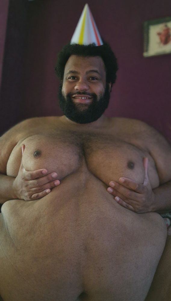 Me, a big sexy superchub, grabbing his moobs, wearing a festive hat for his birthday