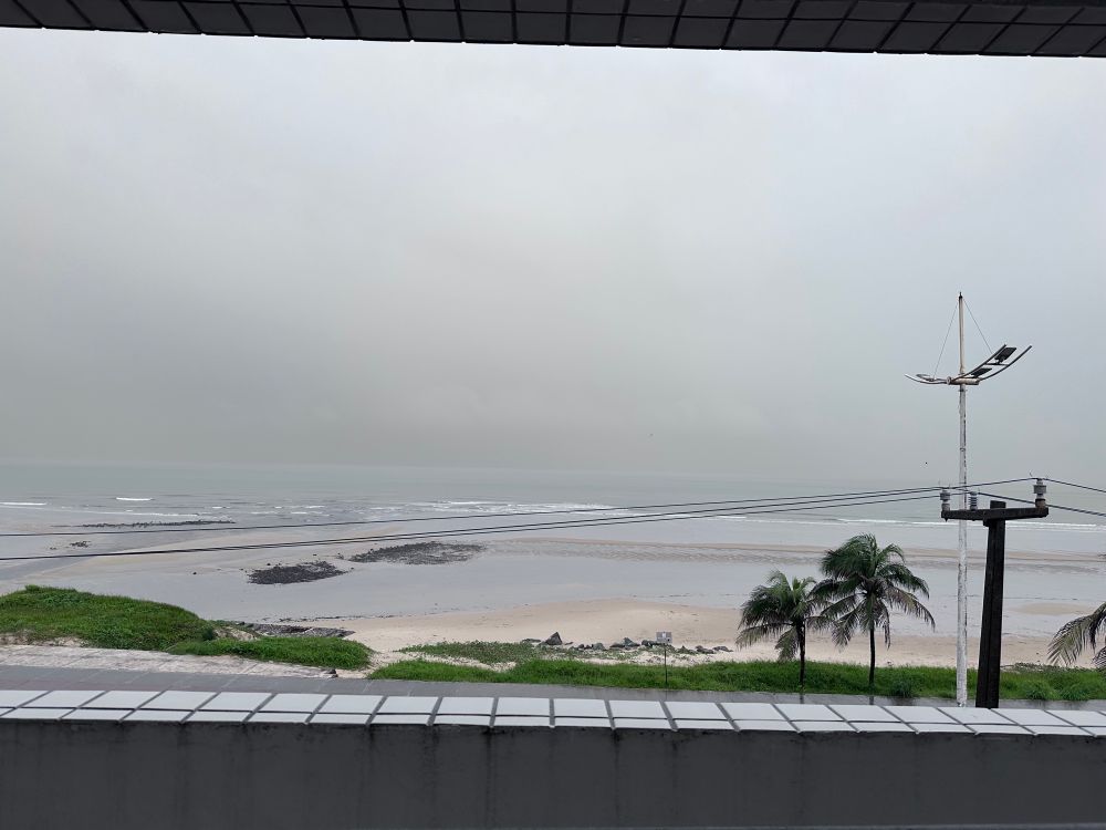 Foto de uma praia com o tempo nublado e chuvoso