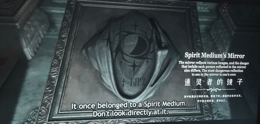 A mirror on a plinth, covered by a cloth. The text reads:

Spirit Medium's Mirror
The mirror reflects various images, and the danger that befalls each person reflected in the mirror also differs. The most dangerous reflection to see in the mirror is one's own.

"It once belonged to a Spirit Medium. Do not look directly at it.