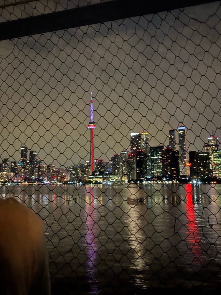 ID: a night time view of the Toronto skyline, taken from a boat sailing on the lake. End Id. 