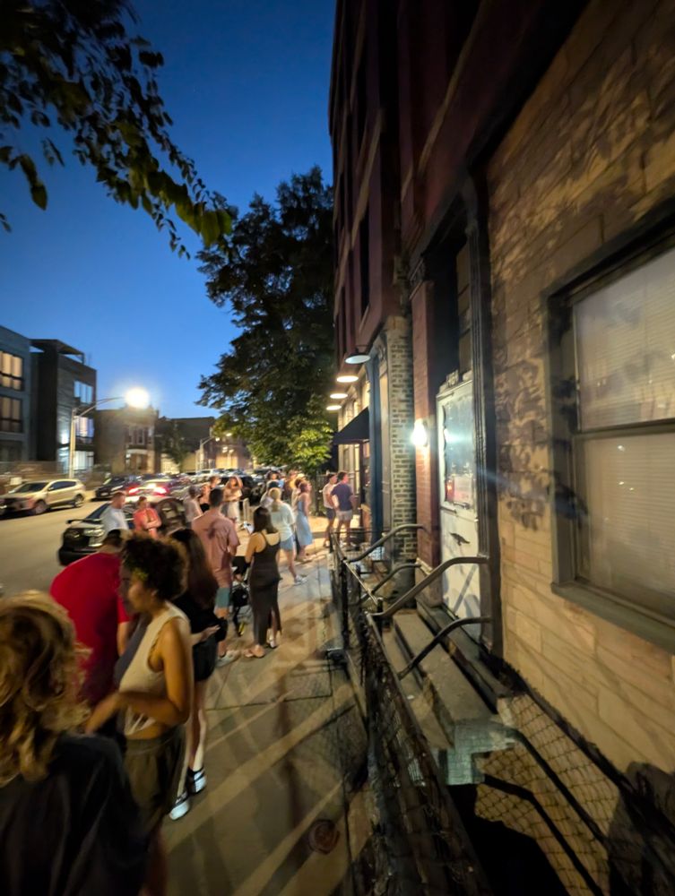 Many people in line for vegan sweet corn soft-serve ice cream on a warm summer's night.
