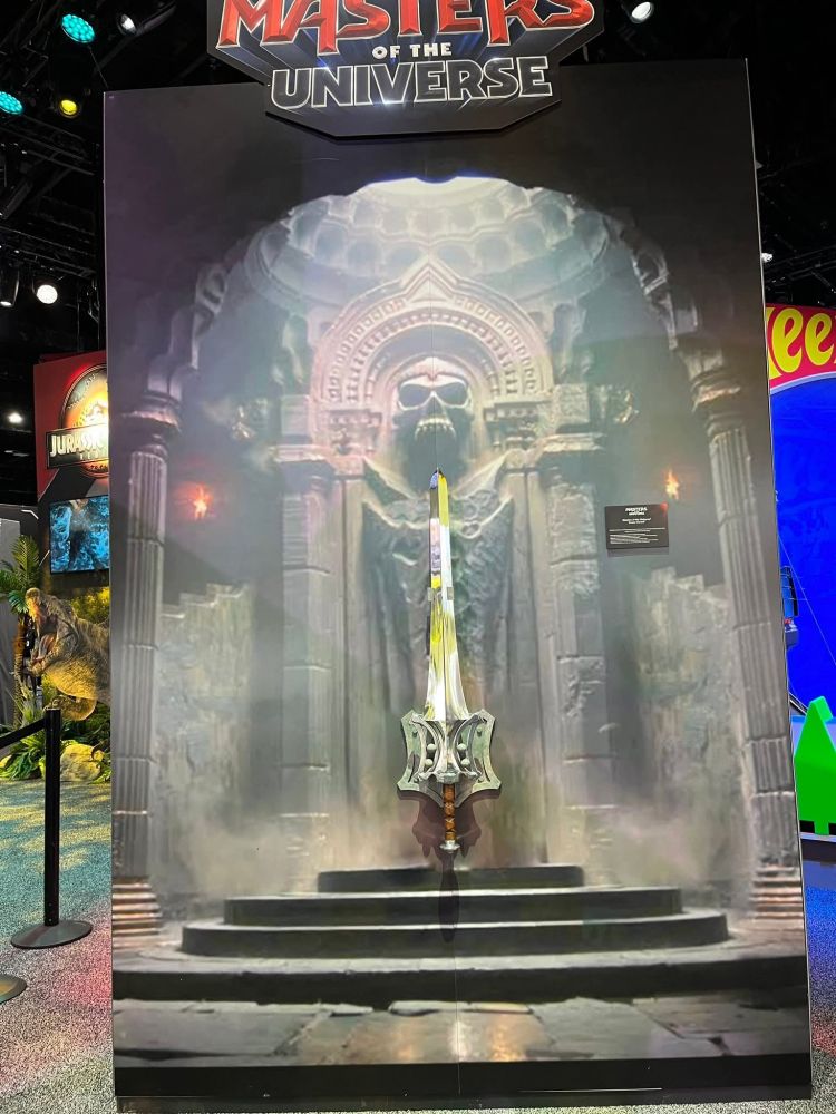 A display for the Masters of the Universe movie at SDCC, showing an interior chamber from Castle Greyskull and a real replica of He-man's iconic Sword of Power.