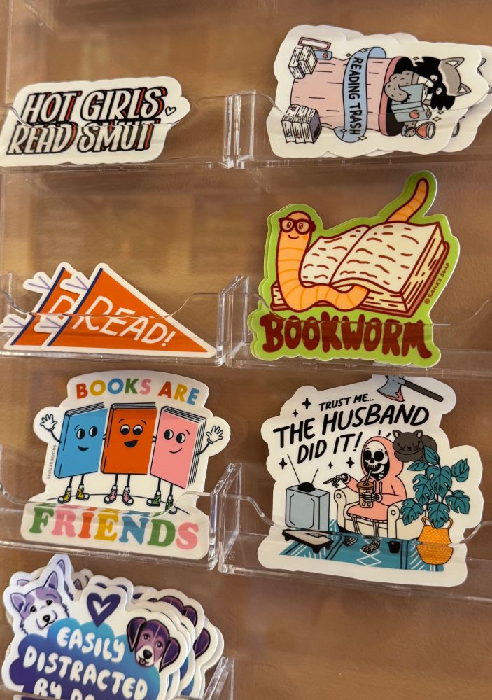 A collection of book lovers’ stickers including a bookworm, easily distracted, the husband did it, and hot girls read smut  
