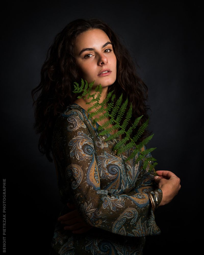 Portrait en studio d'une femme avec une feuille de fougère