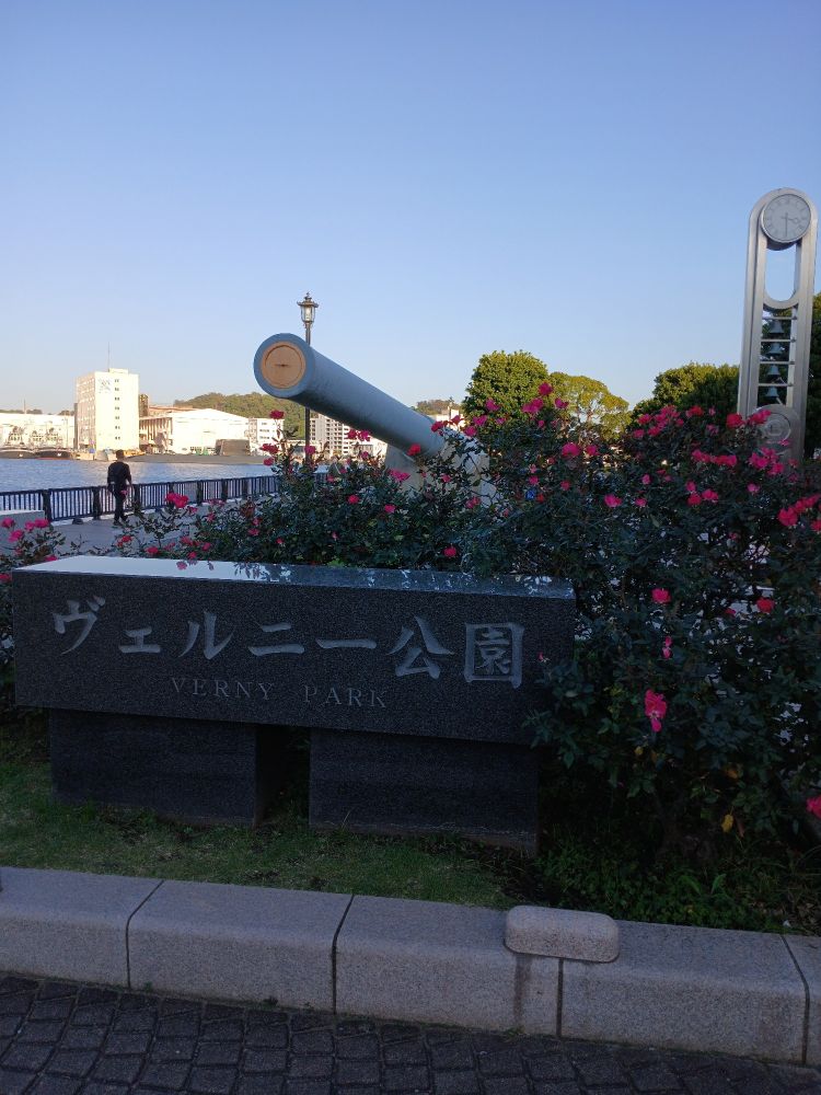 An entrance to Verny Park in Yokosuka, Japan. From behind a clutch of flowers, a plugged main gun salvaged from the Imperial Japanese battleship Mutsu just forth.