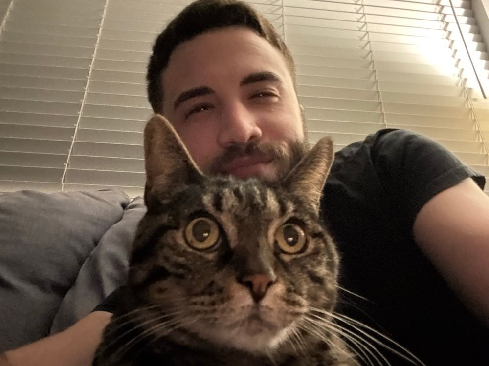 selfie with pepper the tabby cat; she looks comfy and i'm pleased with our friendship