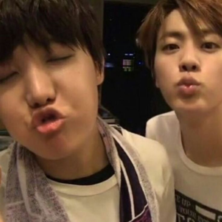 Young hobi and jin being goofy. Hobi has his eyes closed and an exaggerated pout or kissy face for the camera. Jin is next to him also with a kiss face.